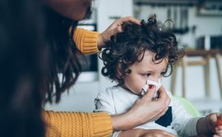 Mother wiping baby's nose