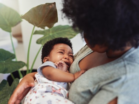 Baby crying in mother's arms